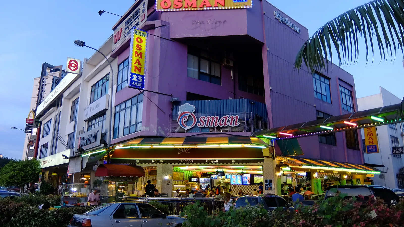 Shophouse restaurants with lit signs at dusk in Bukit Indah, Iskandar Puteri, Johor