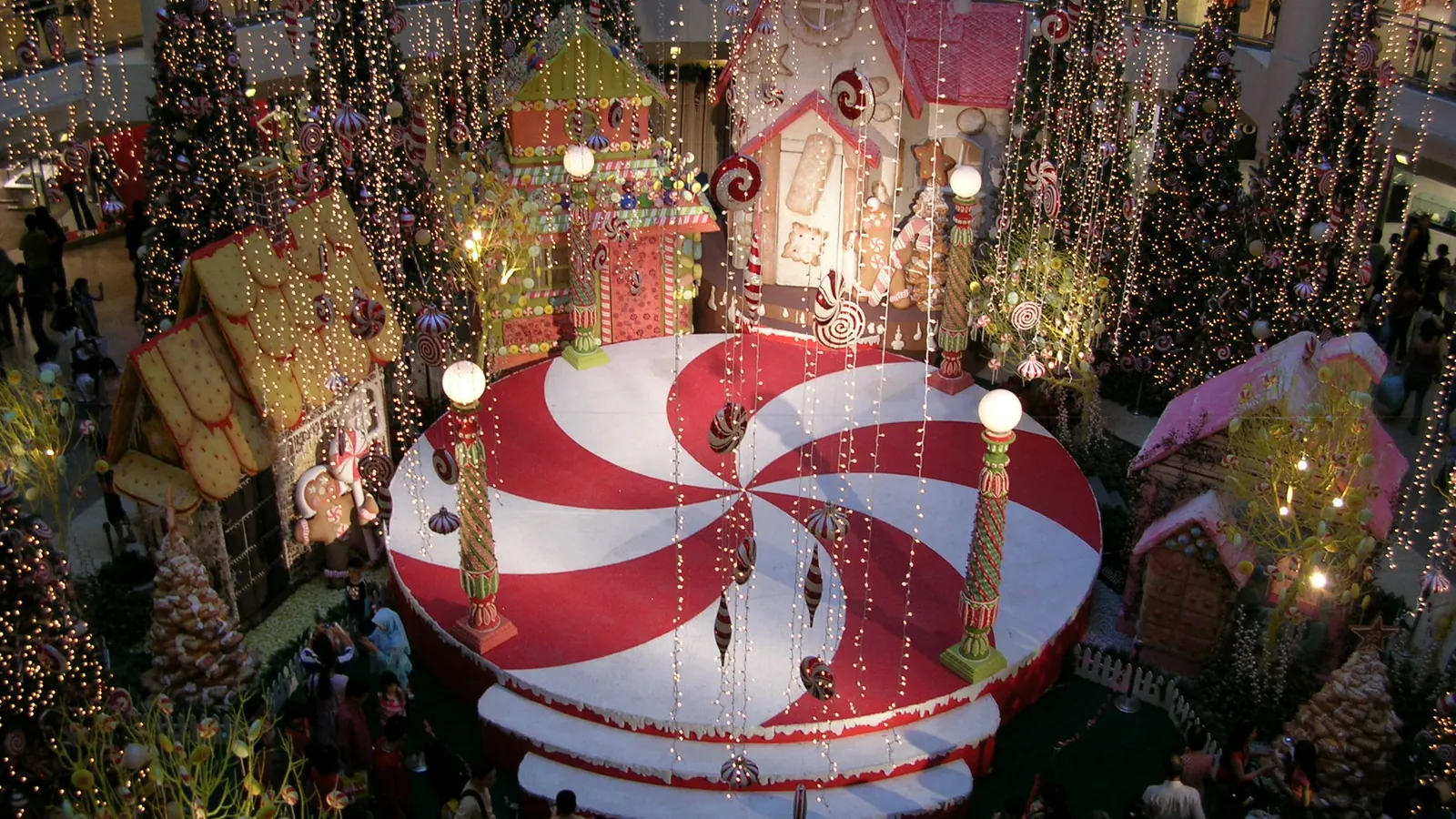 Christmas display with a candy-cane stage, gingerbread houses and lit trees in a Kuala Lumpur shopping mall