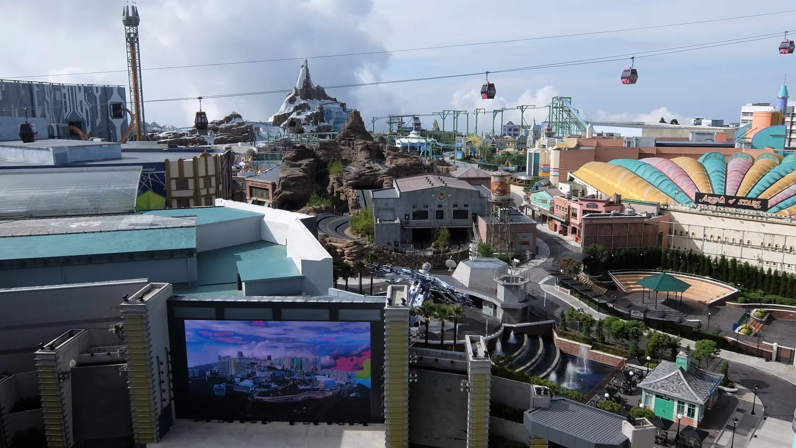 Genting SkyWorlds Theme Park seen from above, with the Ice Age mountain, rides and the cable car passing overhead