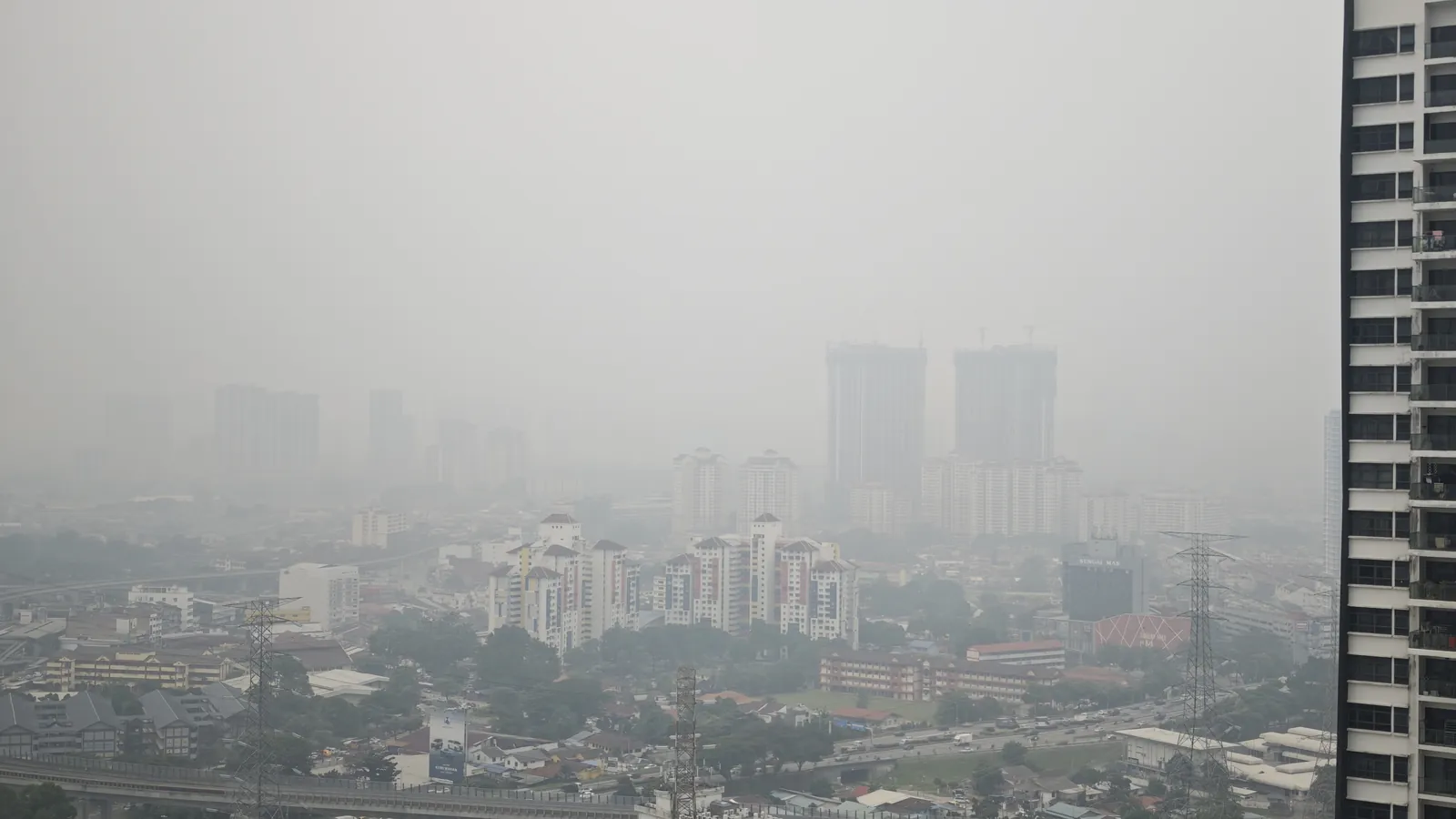 Kuala Lumpur skyline and housing blocks fading into thick grey haze in September 2026