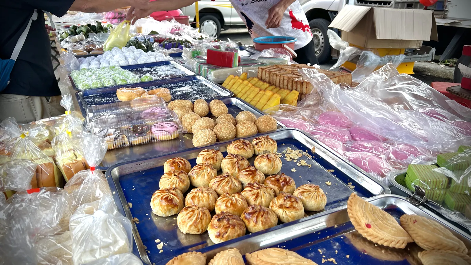 Trays of kuih, curry puffs and sweet snacks on a stall at the Wednesday night market in Bukit Indah, Johor Bahru