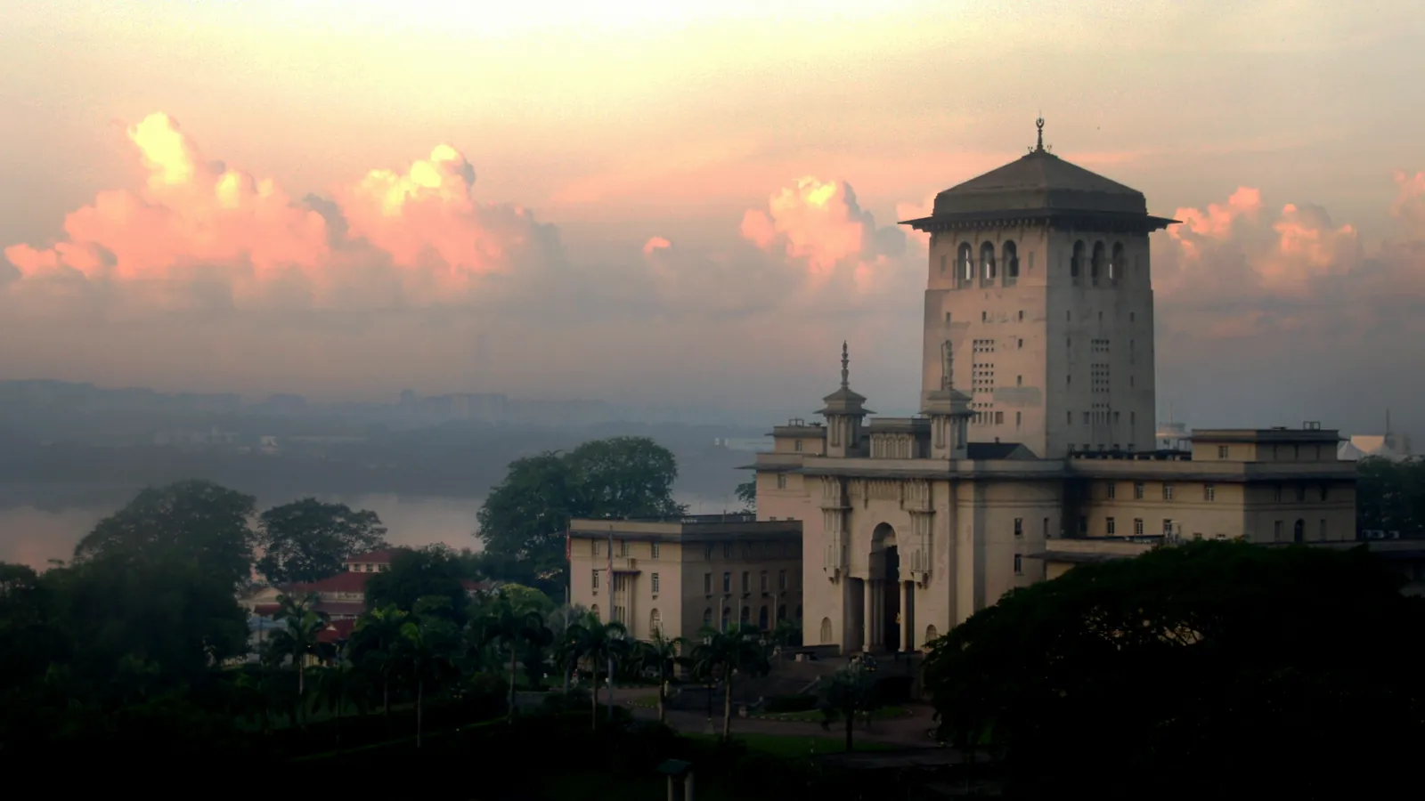 The Sultan Ibrahim Building and its square tower on Bukit Timbalan at sunrise, with the Strait of Johor behind, Johor Bahru