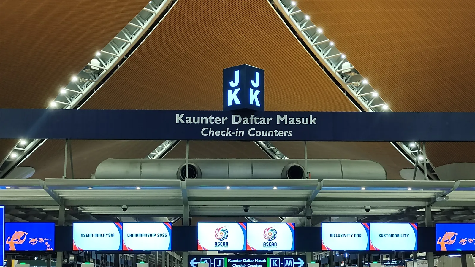 Check-in counter signs under the timber-lined roof of KLIA Terminal 1 departure hall in Sepang, Malaysia