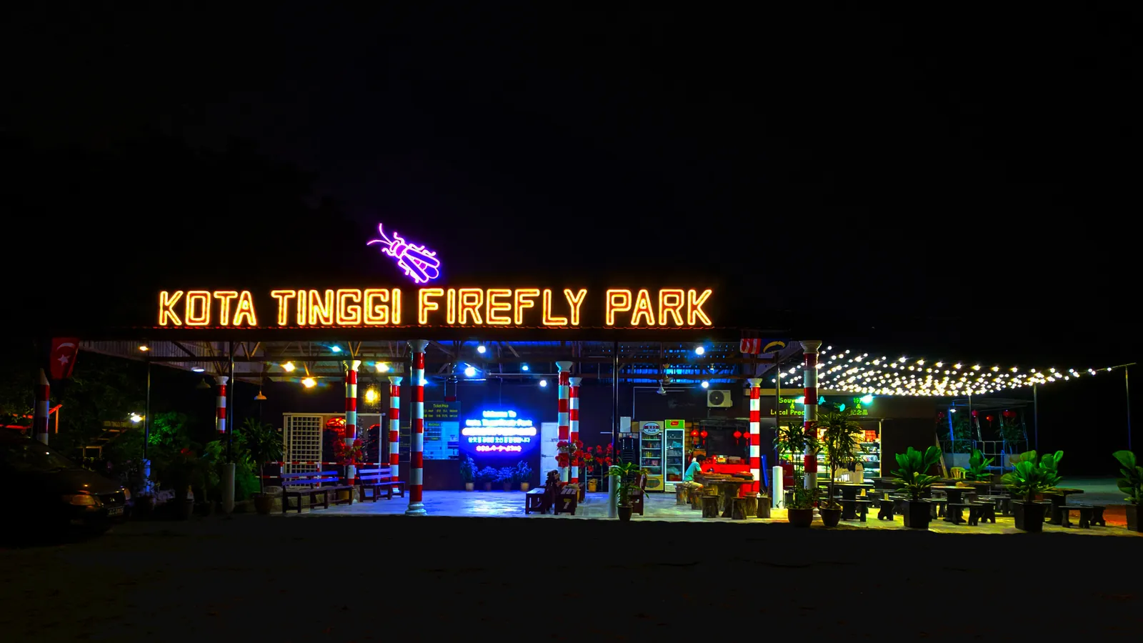 Lit-up entrance sign of Kota Tinggi Firefly Park on the Johor River at night