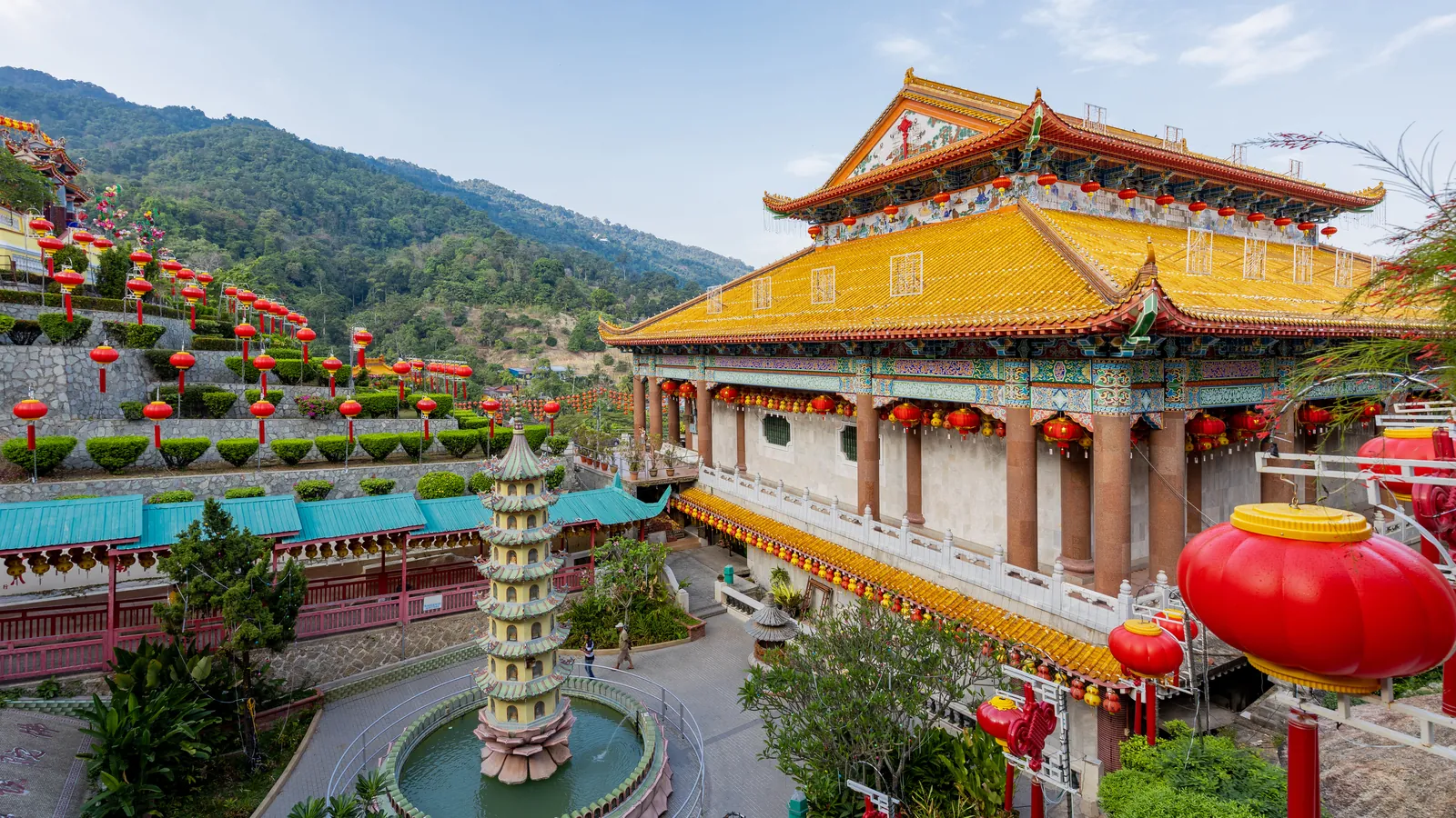 Kek Lok Si Temple in Air Itam, Penang, with its yellow-roofed hall, pagoda fountain and red lanterns against green hills