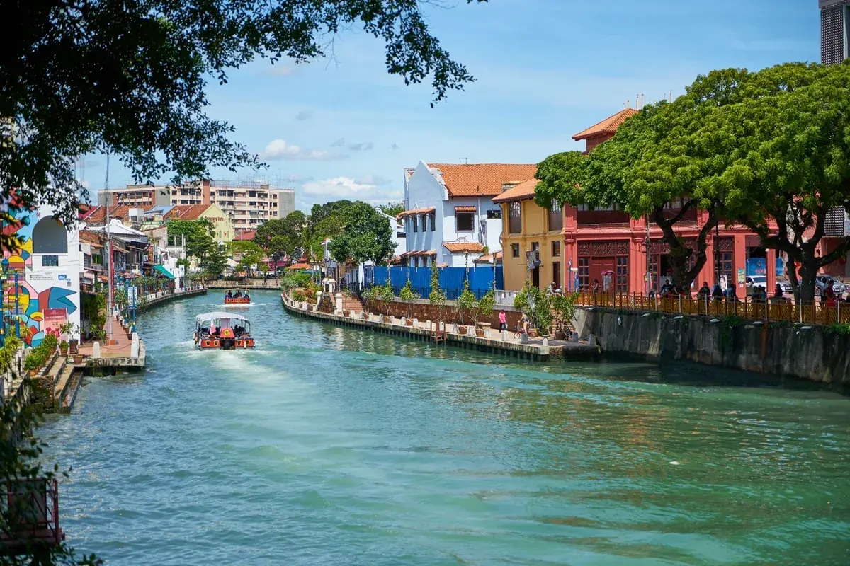 River cruise boat on the Melaka River lined with colourful buildings