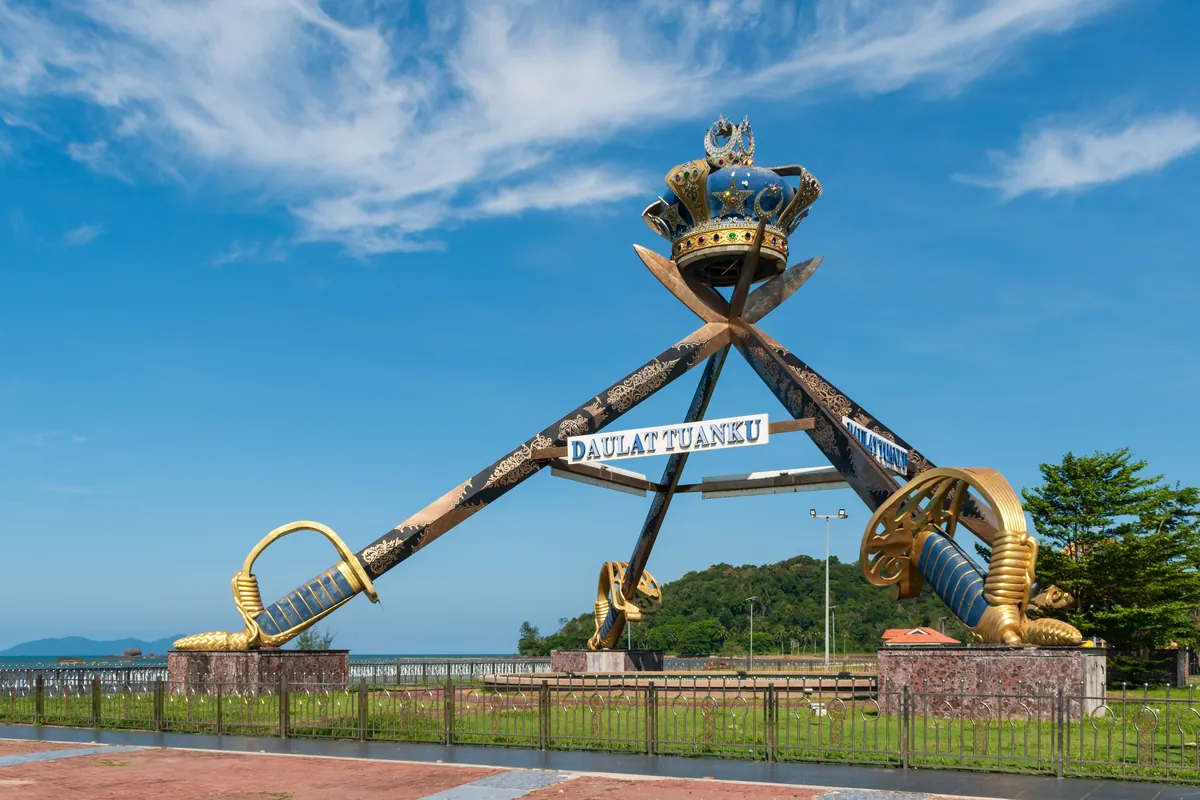 Crown and crossed swords monument on the Mersing waterfront