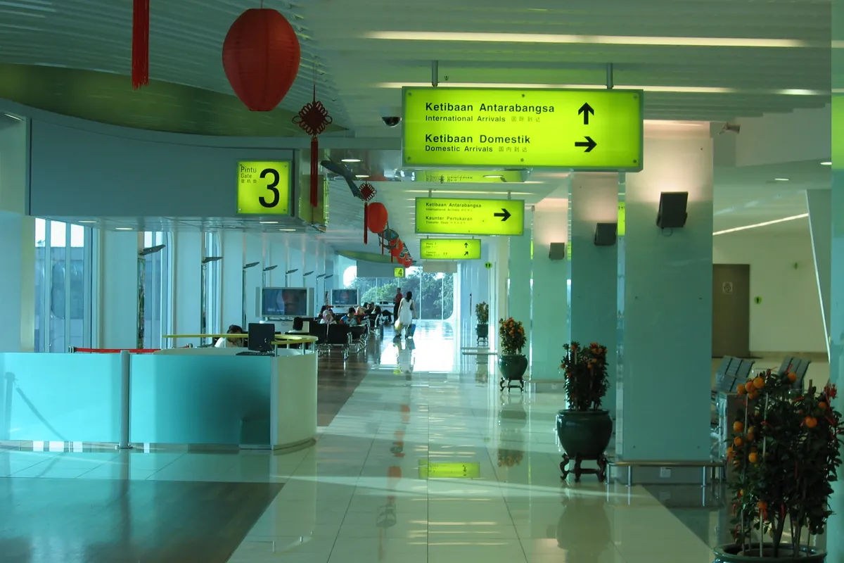 Bright concourse with international and domestic departure signs at Senai Airport